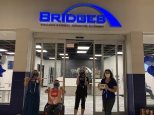 BRIDGES employees holding up communicator masks donated by the MWP