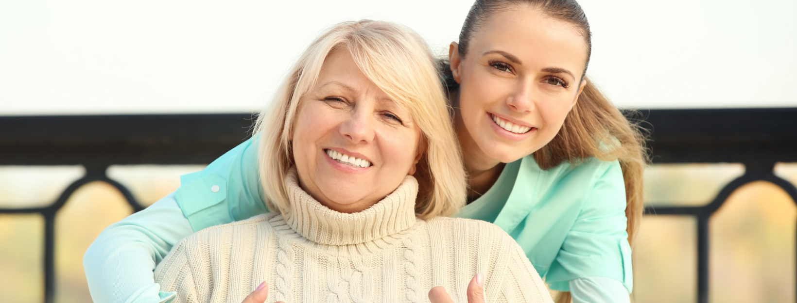 an elderly woan and young woman smiling together