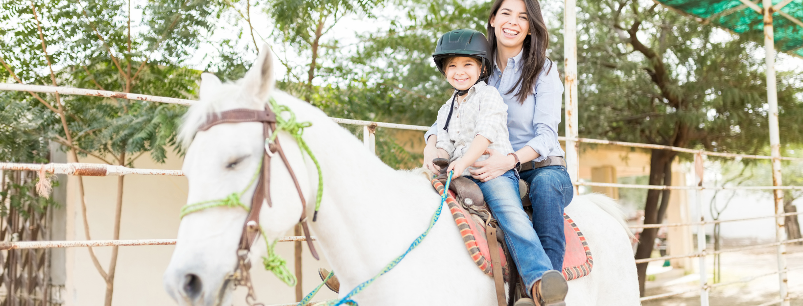 mother nd child smiling on a horse