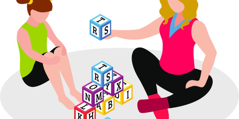 graphic of two girls playing with letter blocks