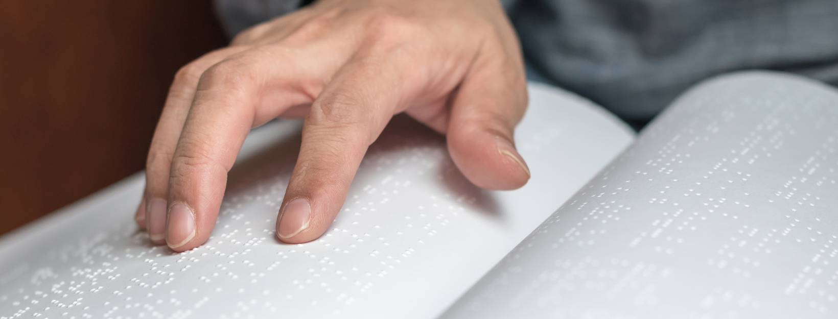 close up of a white man's fingers reading book in Braille close up of a white man's fingers reading book in Braille