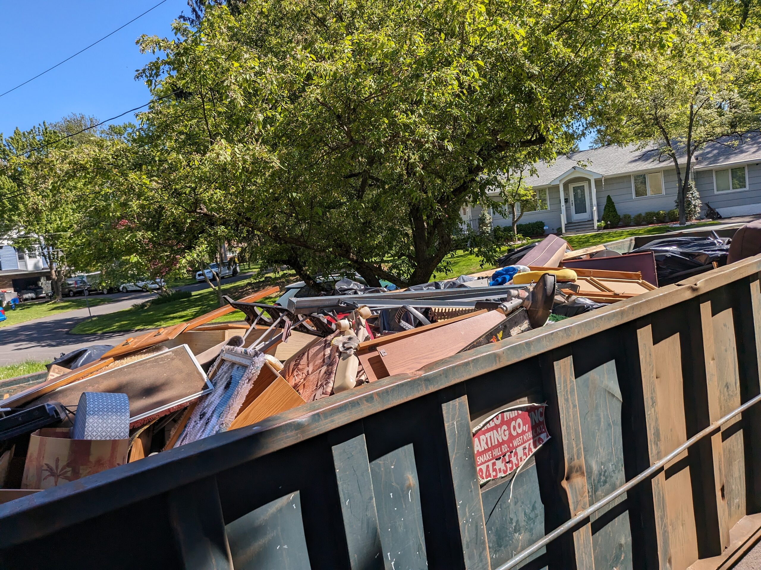 A dumpster full to the top of all the stuff cleaned out from the house